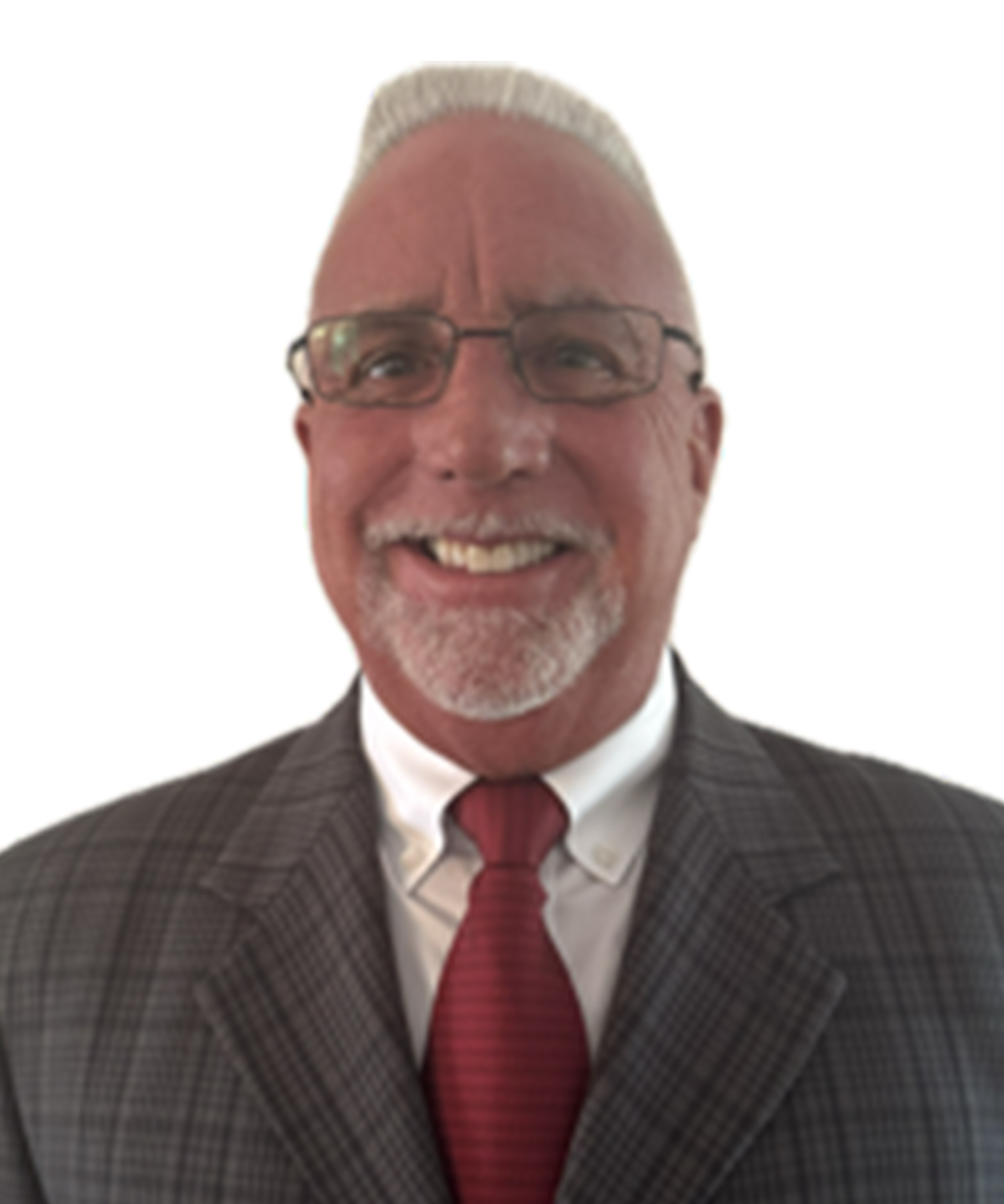 Smiling man with short white hair and goatee wearing glasses, a gray plaid suit, white shirt, and red tie, standing against a white background.